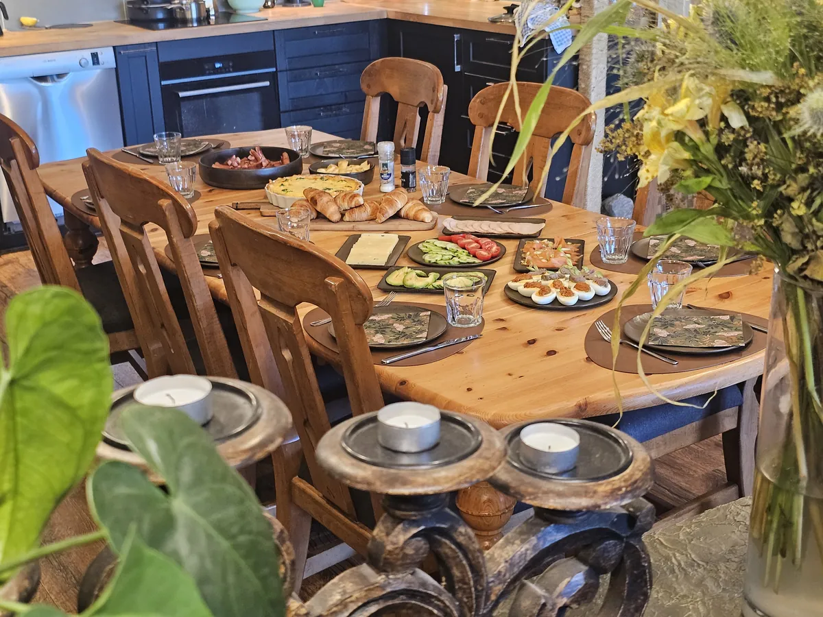 The breakfast table laid for guests, with candles and flowers